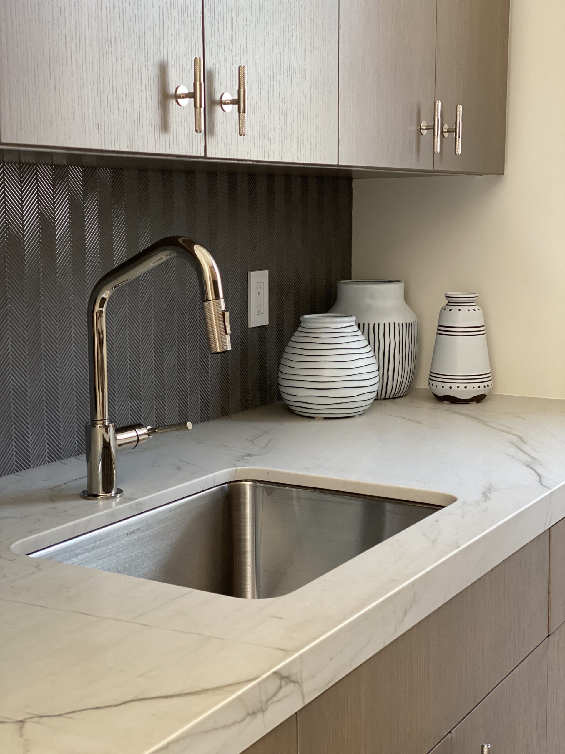 Designer: Lamb Partners | Materials: Quartzite Calacata Leather (Counter), Signature Glass Textile Twill Lunar Gray (Backsplash)