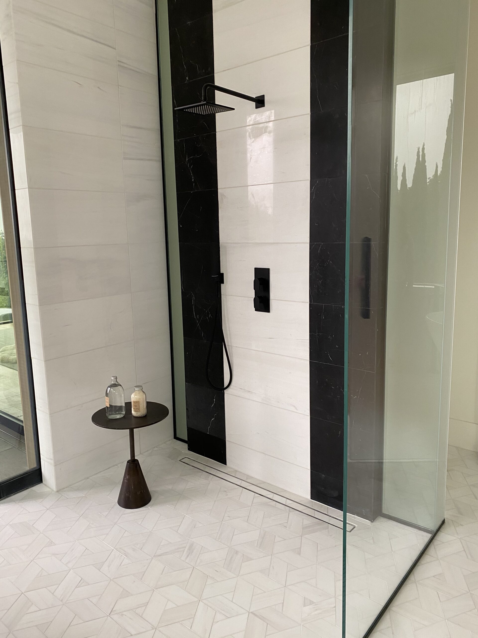 Designer: JIA XU | Architect: Stacey Olgado | Materials: Floor - Enrichment Weave 12, Blanc Dolomite Maison Surface; Shower Walls - Dolomite Polished (left), Thassos Polished (right), Negro Marquina (black stripes)