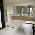 Designer: JIA XU | Architect: Stacey Olgado | Materials: Floor - Enrichment Weave 12, Blanc Dolomite Maison Surface; Shower Walls - Dolomite Polished (left), Thassos Polished (right), Negro Marquina (black stripes)