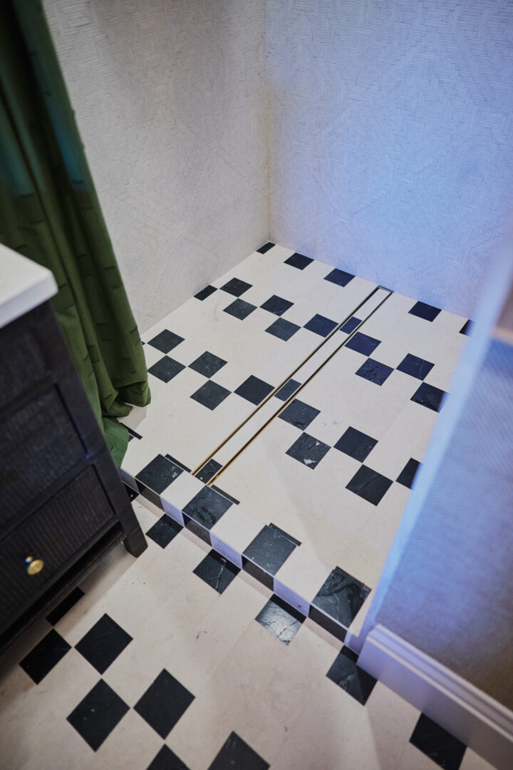Designer: Kendra Nash | Photographer: Arthur Alvarez | Materials: Siena Beige Agarwood Limestone Tumbled Mosaic, Agarwood Limestone Honed, Omega Black Brushed & Pollowed Edge Slab