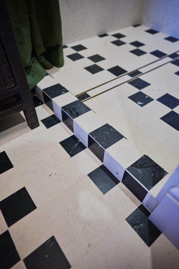 Designer: Kendra Nash | Photographer: Arthur Alvarez | Materials: Siena Beige Agarwood Limestone Tumbled Mosaic, Agarwood Limestone Honed, Omega Black Brushed & Pollowed Edge Slab